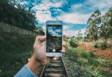 Still Refreshing – Checking In on My Mostly-Free Wireless Plan Years Later a hand holding a phone with a train track in the background