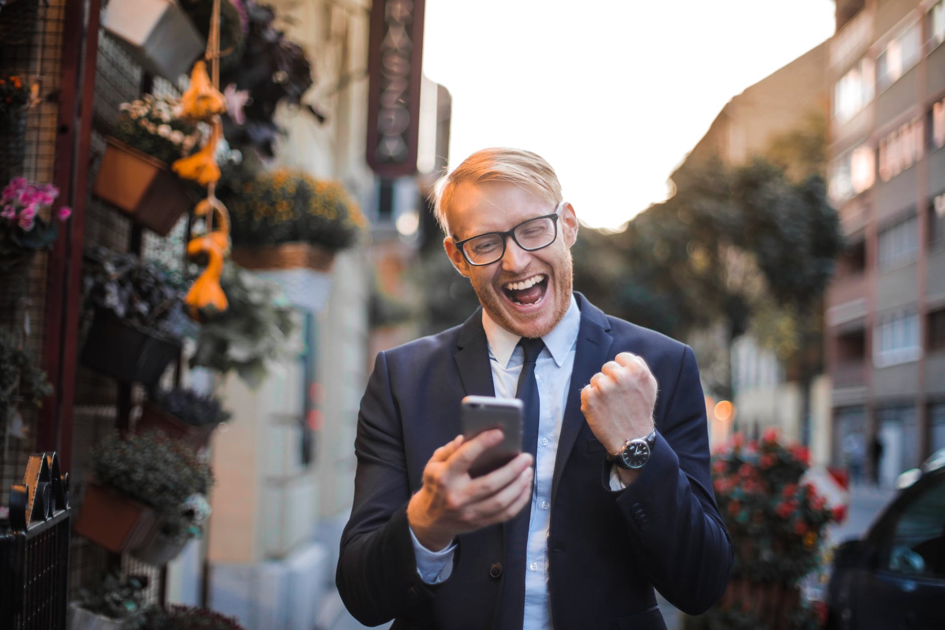 An excited man holds a phone in his hand