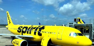 (Updated Information) What Is Happening With Spirit Airlines Credit Cards? a yellow airplane with black writing on it
