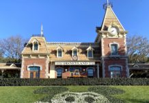 Our First Disneyland Family Vacation Is Coming Together… a building with a clock and a lawn with a cartoon face