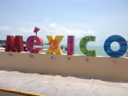 Image of sign saying "Mexico" along a beach