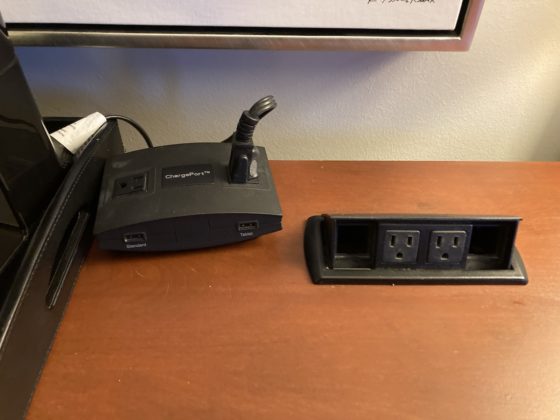 A close-up picture of the power outlets and internet ports on the desk