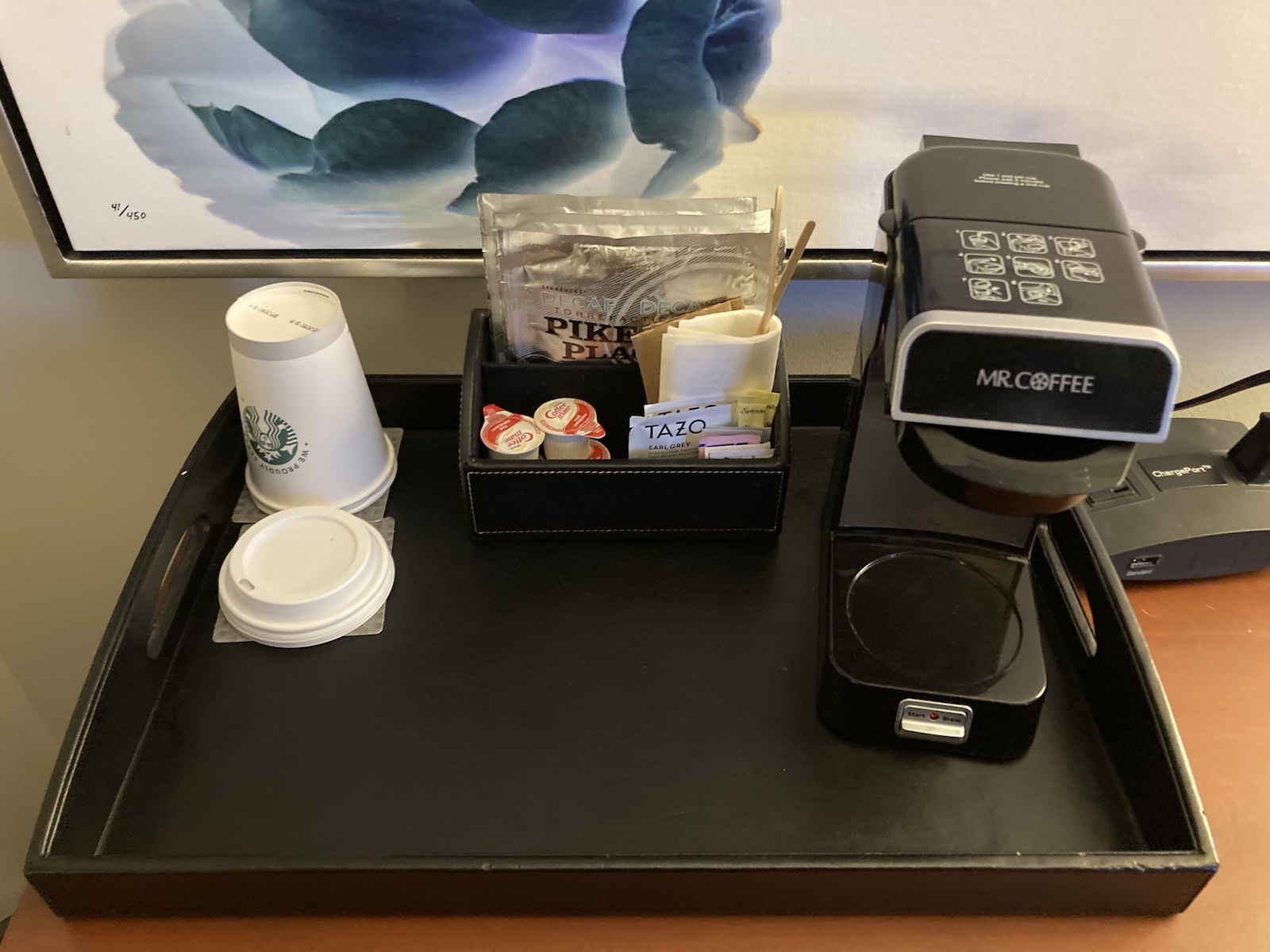 Coffee supplies and a coffee maker sit on the desk