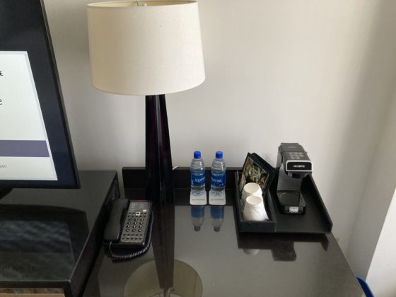 Lamp, bottled water, and coffee supplies on a desk
