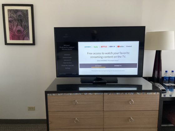 A large TV on top of a dresser