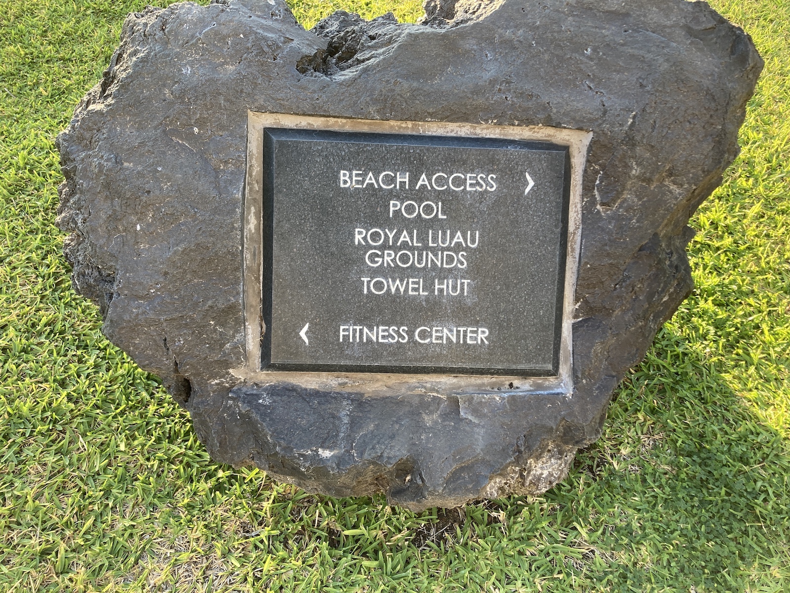 Photo of a metal plaque engraved in a rock giving directions