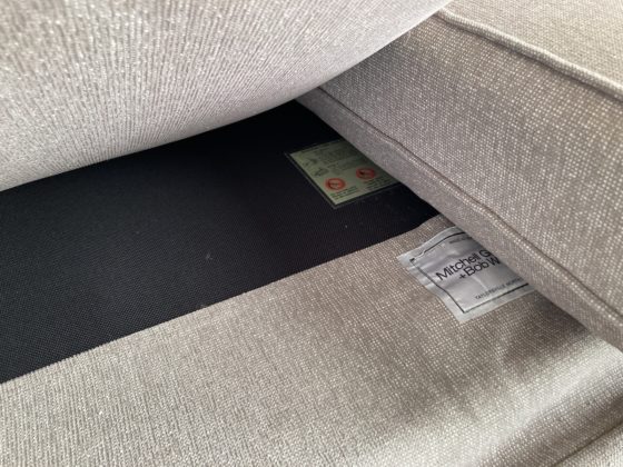 A lifted couch cushion reveals a fold-out bed