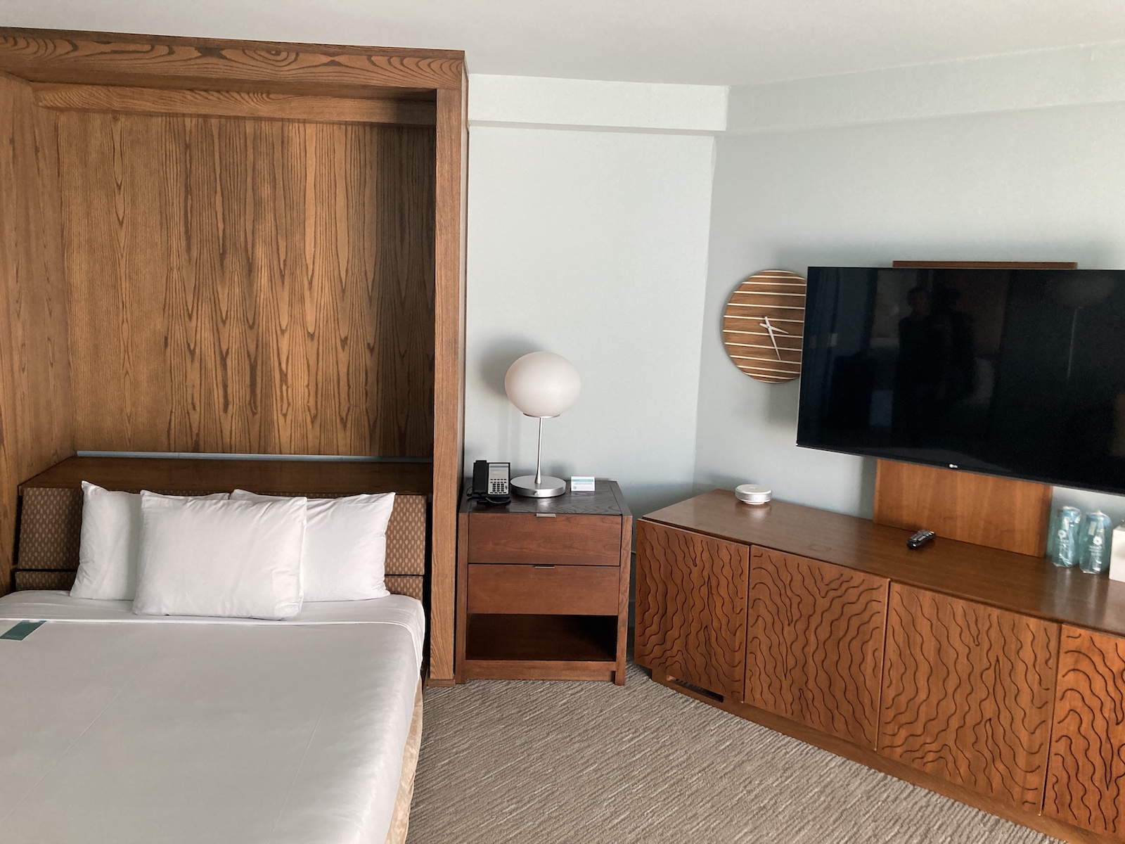 Photo shows the Murphy bed on the left side, a nightstand in the middle, and a dresser with TV above it on the right side