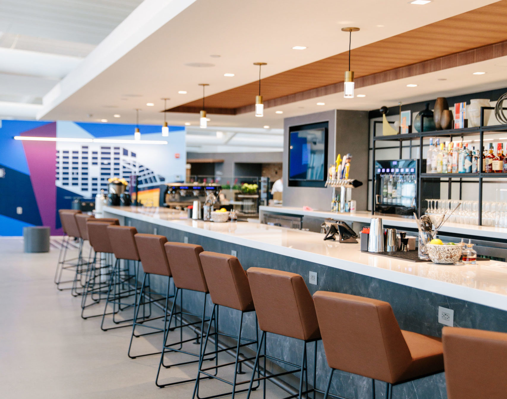 a bar with brown chairs and a tv