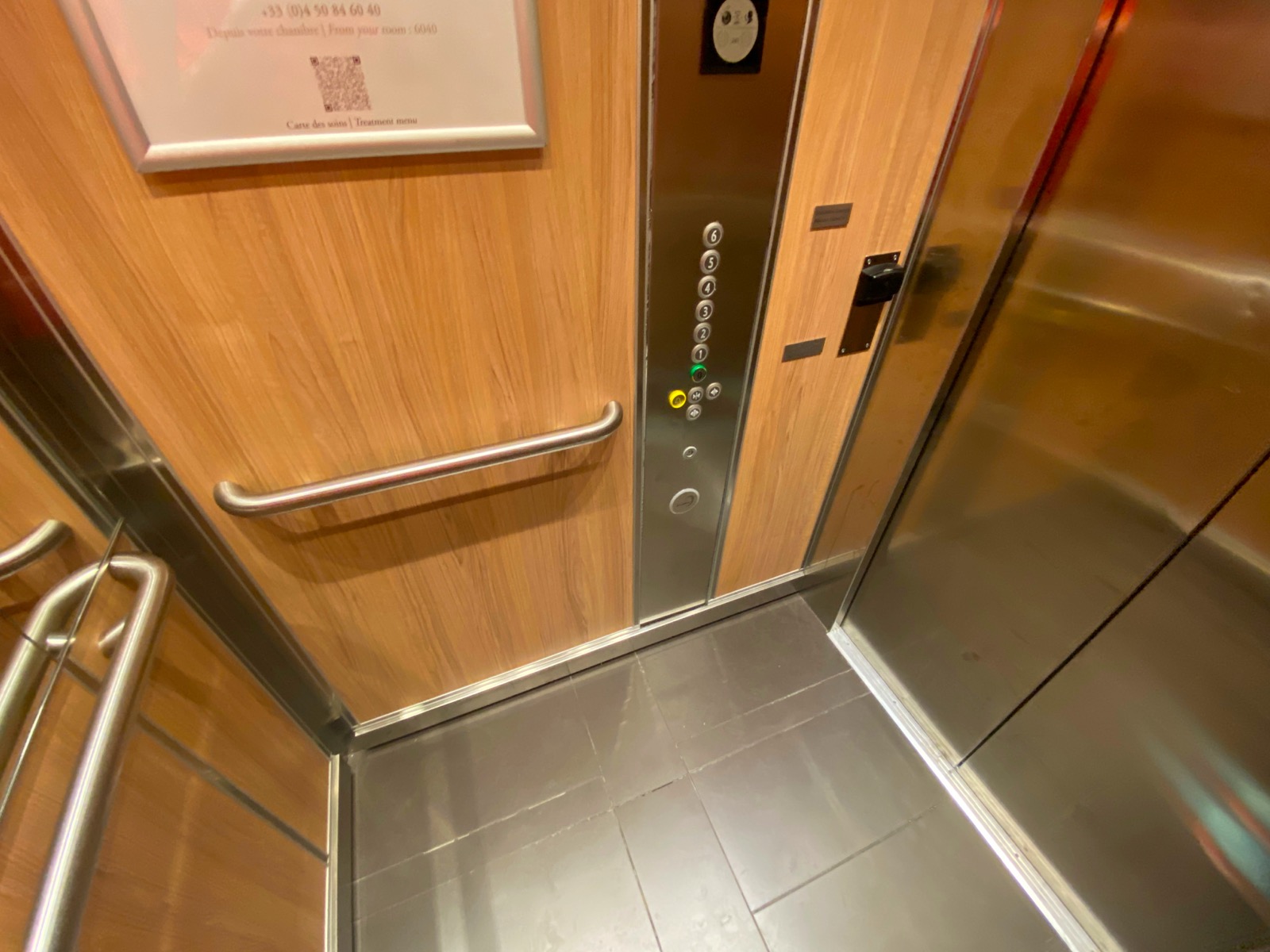 a elevator with buttons and a metal handle