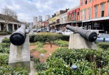 Over the Top Guide to Visiting New Orleans – Where to Eat, Sleep & Have So Much Fun in the Big Easy! two cannons on concrete pillars in a city