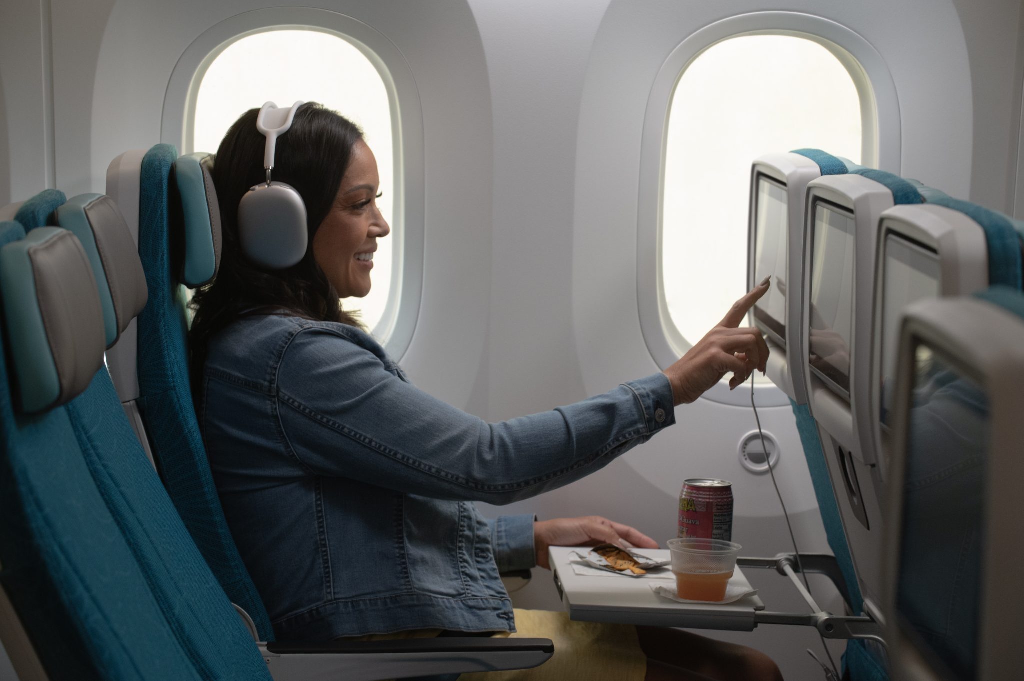 a woman sitting in an airplane with headphones on