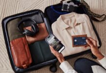 American Express Launches New Bonuses on Hilton Cards, And We Have Some NLL Links For You a person holding a phone and a credit card in their suitcase