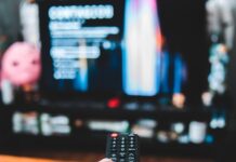 How I Got a YouTube TV Refund and Maybe You Can, Too a hand holding a remote control in front of a television