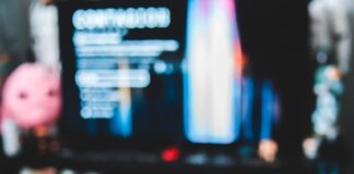 Save Up To $60 On YouTube TV With New Amex Offer a hand holding a remote control in front of a television