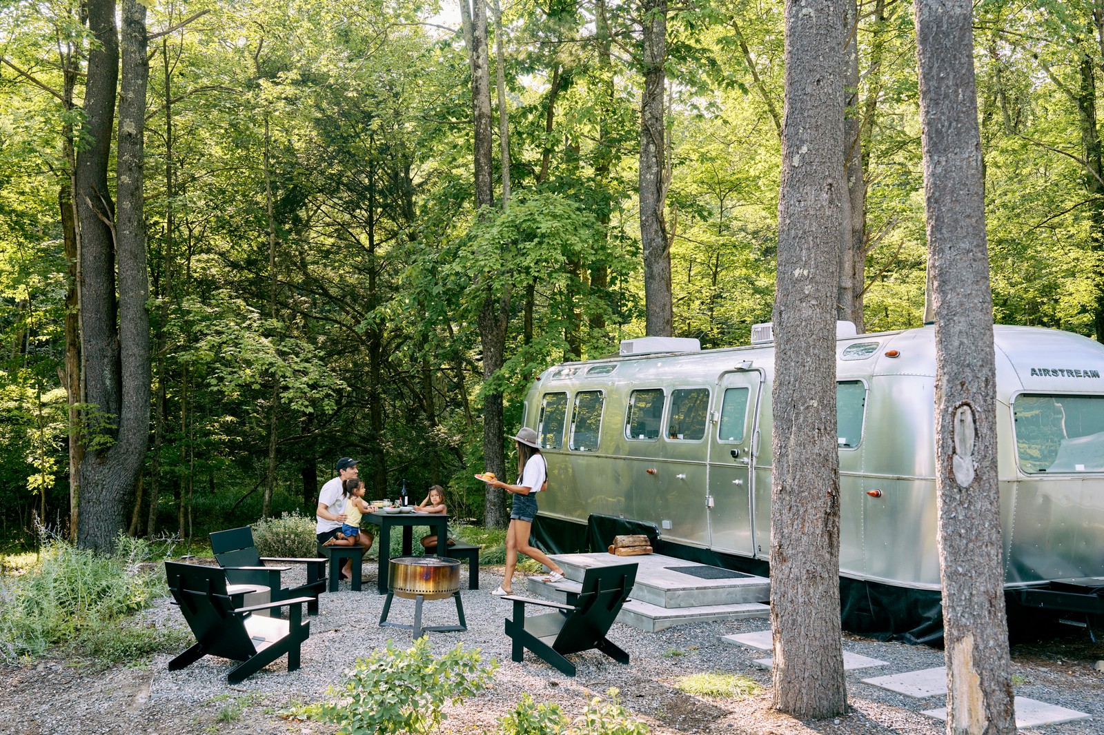 a group of people outside a camper