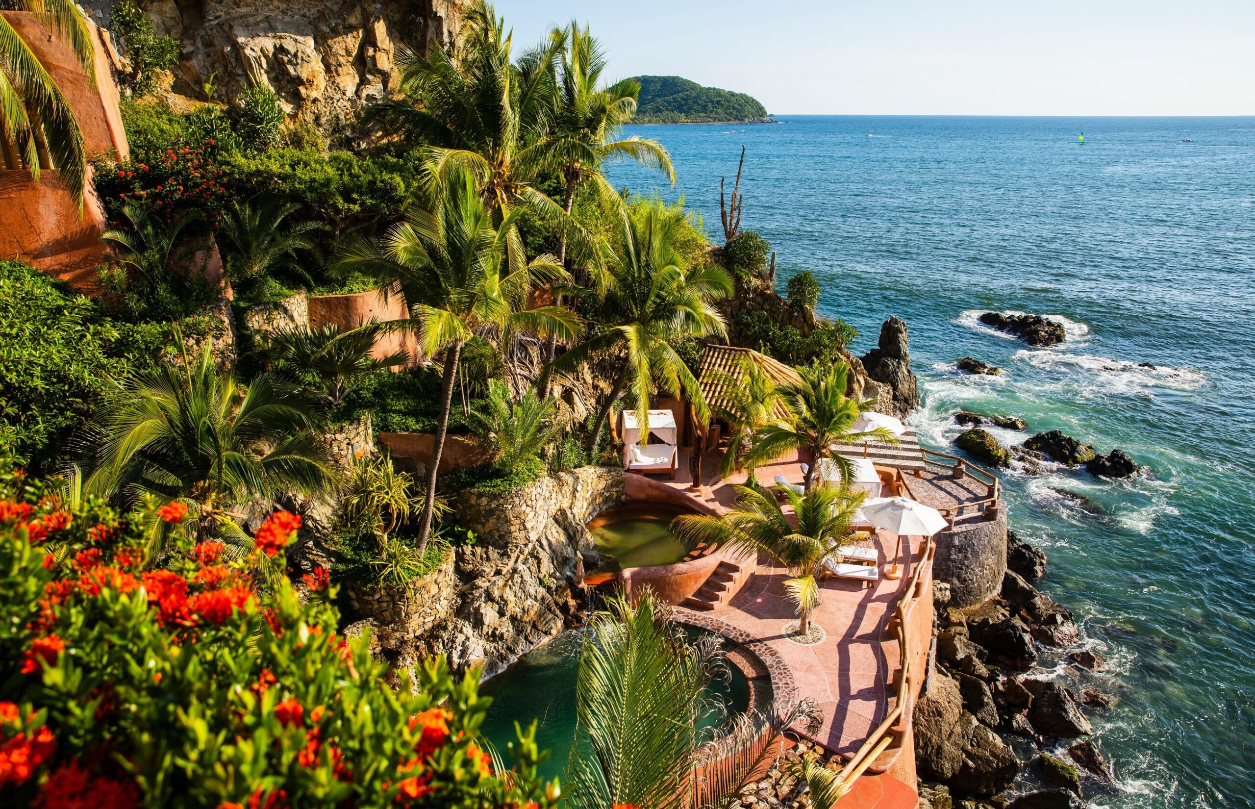 a pool on a cliff overlooking a body of water