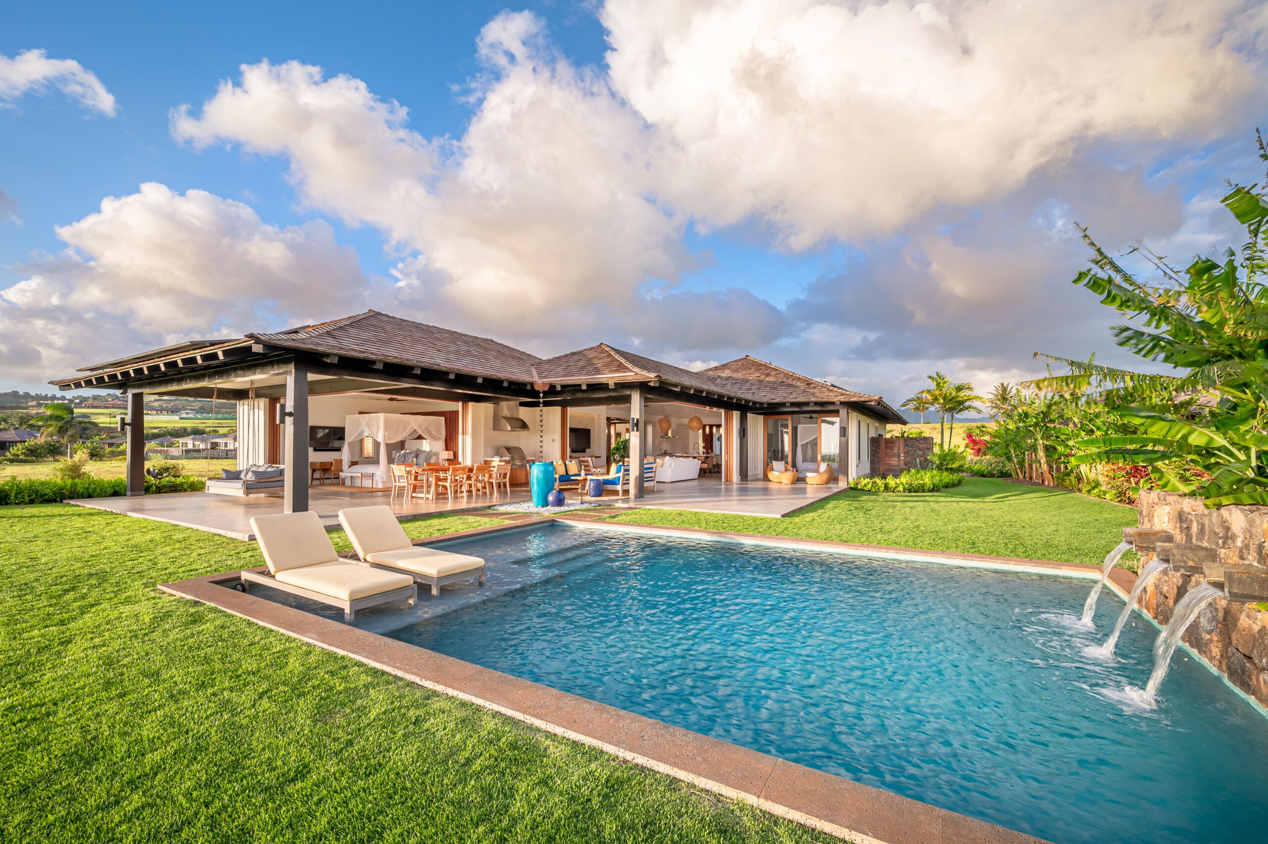 a pool and a house with a roof and a covered patio