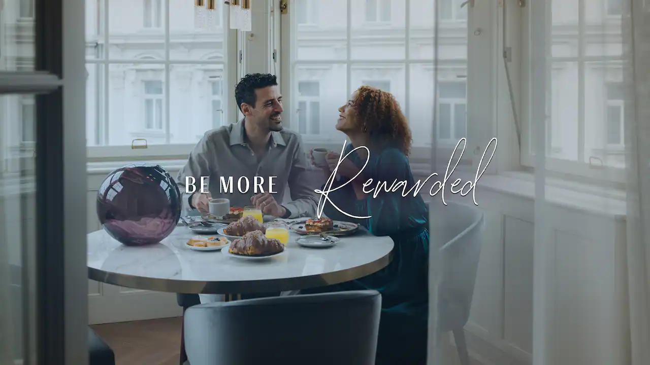 a man and woman sitting at a table with food