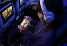 Earn Up to 110,000 Miles and 2,000 PQP with Chase United Cards a woman in a plane with headphones and a cell phone