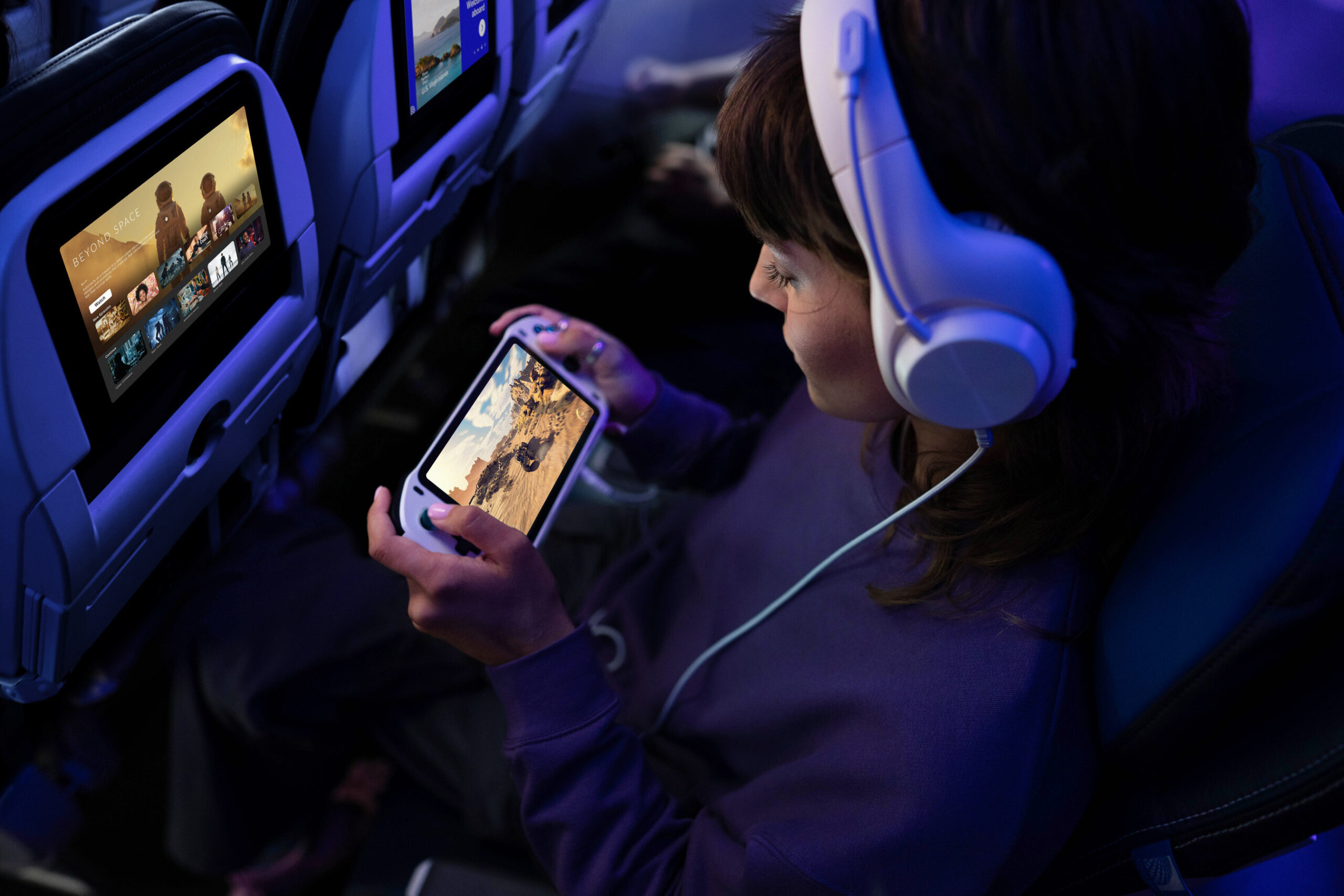 a woman in a plane with headphones and a cell phone