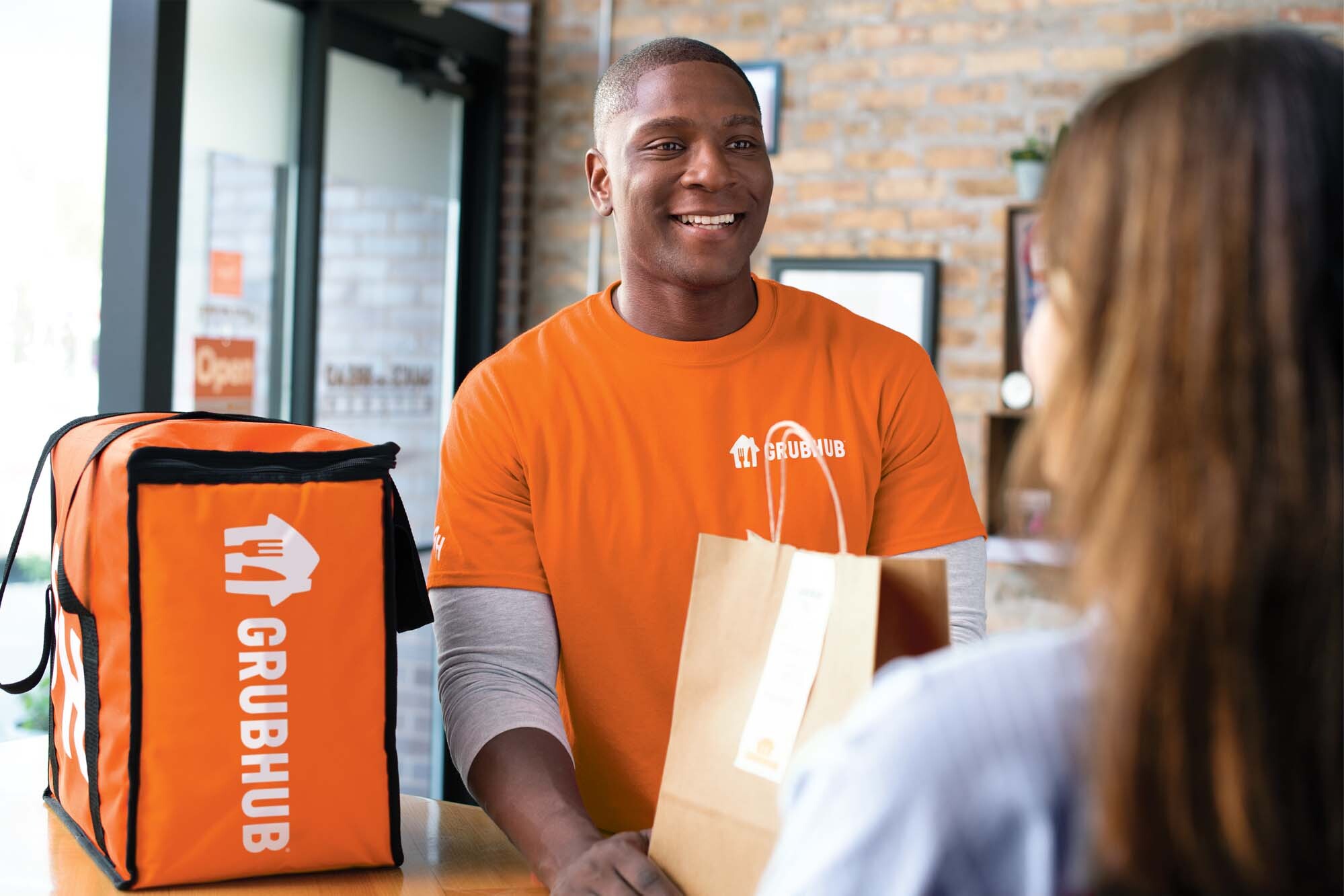 a man in an orange shirt smiling at a woman