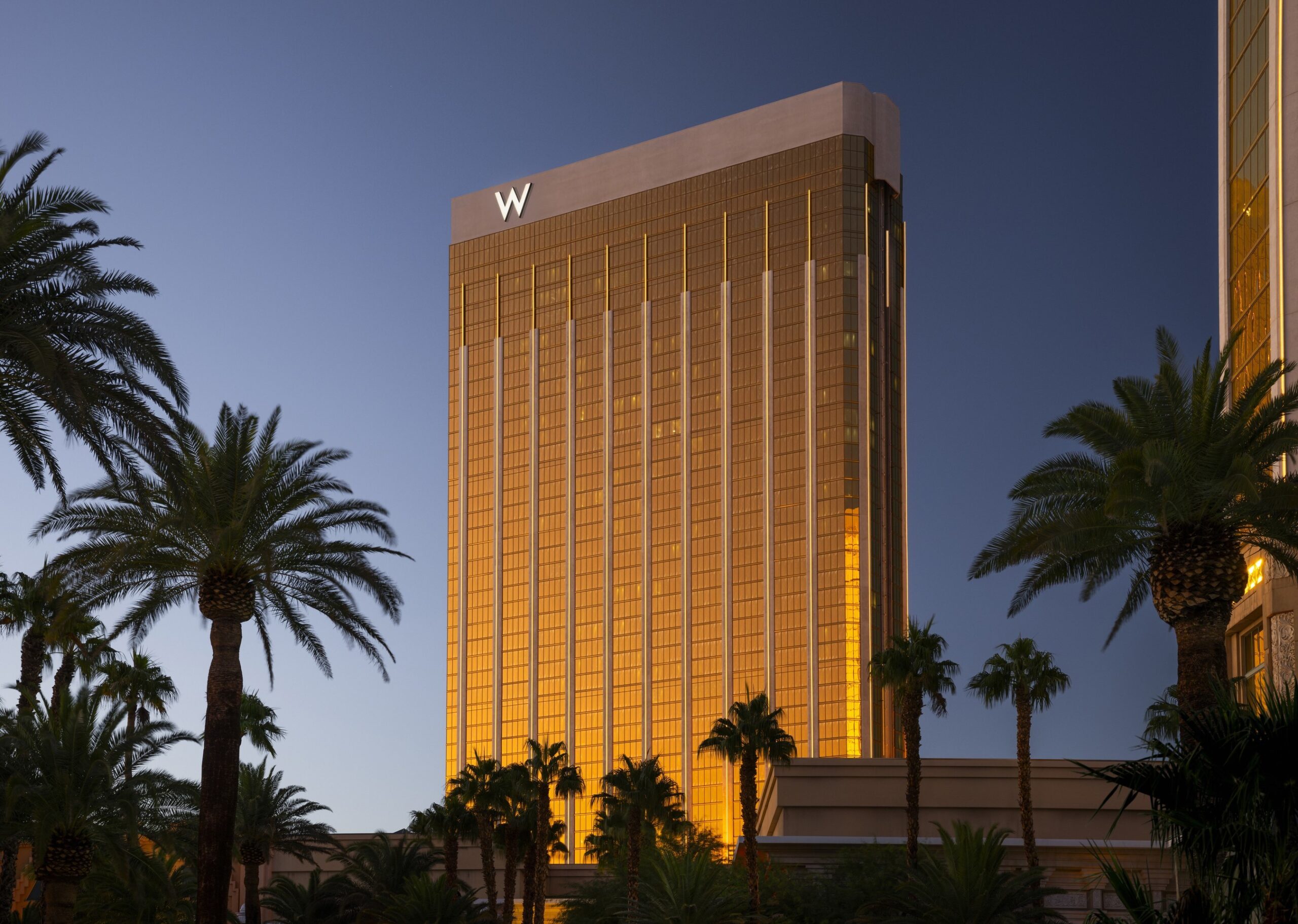 a tall building with palm trees