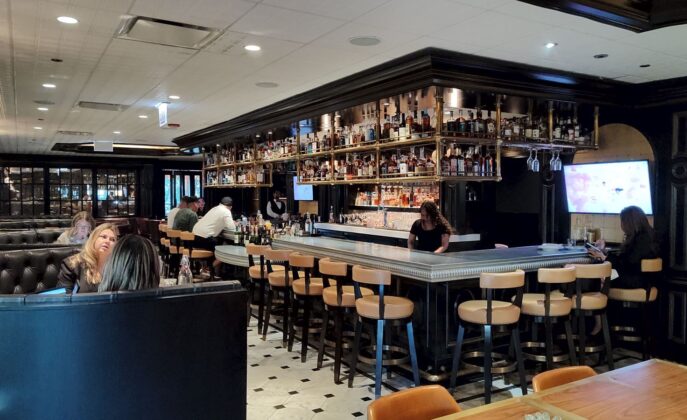 a bar with a group of people sitting at the counter