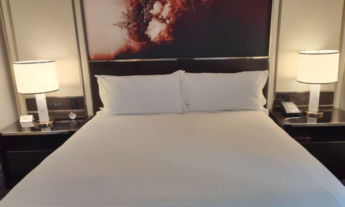 a bed with white sheets and a lamp