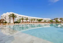 Wyndham Expands All-Inclusive Portfolio with Five New Resorts in Spain a pool with chairs and a building in the background