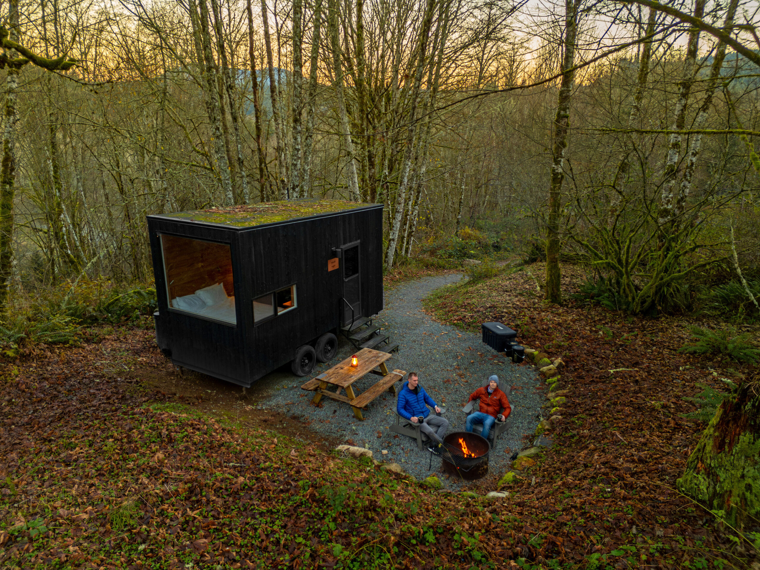 people sitting in a small area with a black container and a fire pit