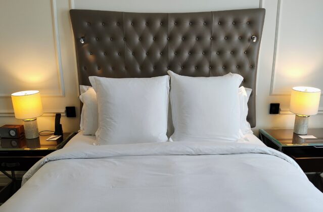 a bed with white pillows and a brown headboard