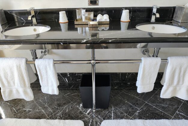 a bathroom sink with white towels on the wall